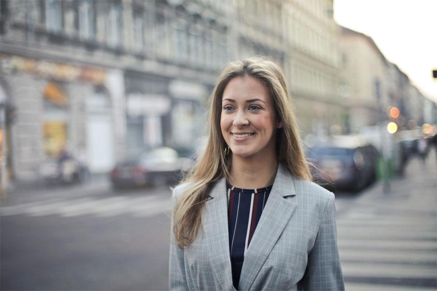A young lady smiling while crossing the road