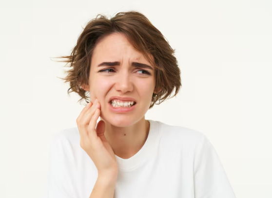 an image of a young woman touching her jaw in pain